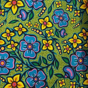 May include: A vibrant floral pattern featuring large blue and yellow flowers with pink and orange centers, set against a green dotted background. The design includes black stems and green leaves, creating a bold, colorful textile design.