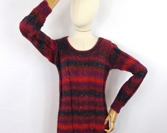 May include: A red, black, and purple striped sweater with a round neckline and long sleeves. The sweater is made of a soft, knitted fabric.
