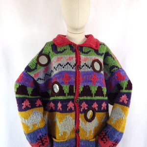 May include: A colorful, button-down sweater with a red collar and trim. The sweater features a variety of patterns and colors, including green, purple, yellow, and blue. It has circular cutouts and a camel design.