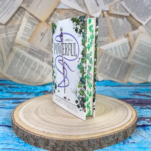May include: A paperback book titled "Powerful" by Lauren Roberts, a New York Times bestselling author of "The Palace of Mirrors". The book cover features a purple and white design with a sword and vines.