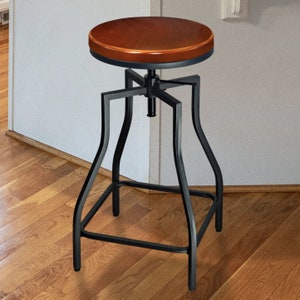 May include: A black metal swivel bar stool with a brown wooden seat. The stool has a square base and a simple design.