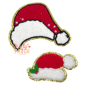 May include: Two Santa Claus hat patches. The hats are red with white trim and a gold glitter border. One hat has white snowflake accents. The other hat has green holly and red berry accents. The text "Crafty Patch Studio" is visible.