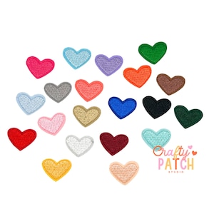 May include: A collection of embroidered heart patches in various colors, including pink, blue, purple, orange, brown, black, and green. The patches are arranged on a white background. The text "Crafty Patch Studio" is visible in the lower right corner.