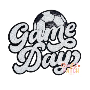 May include: A black and white sequined patch with the words "Game Day" in a cursive font. A soccer ball is featured above the word "Day". The patch also includes the text "Crafty Patch Studio".
