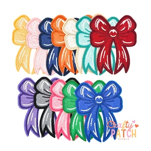 May include: A collection of embroidered bow patches in various colors, including yellow, pink, navy, orange, white, teal, red, purple, gray, green, and blue. Each bow has a white outline and a small embroidered face in the center.