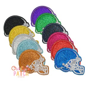 May include: A collection of glittery football helmet patches in various colors, including black, gold, silver, blue, orange, green, purple, pink, red, and blue. Each patch features a white embroidered outline and the "Crafty Patch Studio" logo.