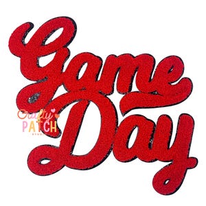 May include: Red glittery "Game Day" script with a black outline. The text is in a cursive font. The logo for Crafty Patch Studio is in the lower left corner. The background is white.
