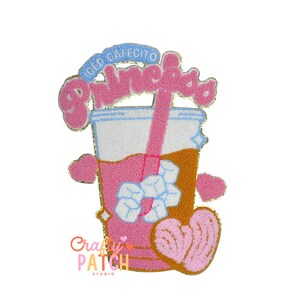 May include: A pink and gold patch featuring an iced cafecito drink with a straw, ice cubes, and heart accents. The patch has the words "Iced Cafecito" and "Princesa" in a bubble font. The patch also has the words "Crafty Patch Studio".