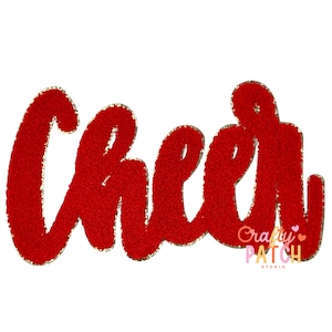 May include: Red, glittery "Cheer" word art with gold trim. The word is in a cursive font. The image includes the text "Crafty Patch Studio" in a smaller font.