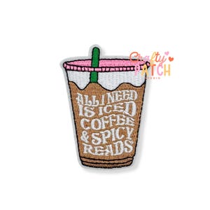 May include: An embroidered patch shaped like a cup of iced coffee with a green straw. The cup features a white lid, a brown body, and white text that reads ALL I NEED IS ICED COFFEE & SPICY READS. The design has a pink rim and white stitching.