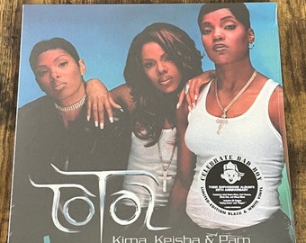 May include: A vinyl record cover featuring a group of three women, with the group name "Total" in silver lettering and the text "Kima, Keisha & Pam" below. The cover has a black and white circular sticker with the text "Celebrate Bad Boy: Their Sophomore Album's 25th Anniversary. Limited Edition Black & White Vinyl."