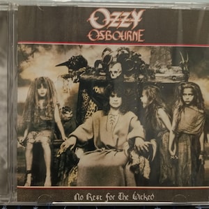 May include: CD case featuring the album cover for Ozzy Osbourne's "No Rest for the Wicked." The artwork depicts Osbourne seated, surrounded by figures in a dark, gothic setting. The album title and artist name are displayed at the top and bottom.
