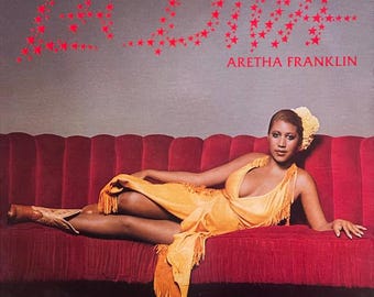 Könnte beinhalten: Eine Frau in einem gelben, fransigen Kleid liegt auf einem roten Samtsofa. Der Hintergrund ist eine hellgraue Wand mit dem Wort "LOVE" in roten Sternen. Der Text "ARETHA FRANKLIN" ist unter dem Sofa gedruckt.