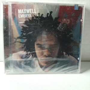 Puede incluir: Una caja de CD con el álbum "Embrya" de Maxwell. La portada muestra un retrato de una persona con cabello oscuro. El título del álbum y el nombre del artista están impresos en texto blanco en la esquina superior izquierda.