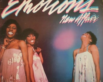 May include: Album cover for "The Emotions - New Affair." The album art features three women in dresses, with the title in a stylized font. The background is dark with a pink and blue gradient.