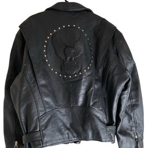 May include: Black leather motorcycle jacket with a Harley Davidson eagle logo on the back. The logo is surrounded by silver studs.