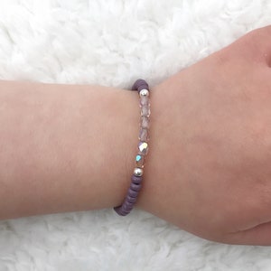 May include: A purple beaded bracelet with clear iridescent beads and silver spacers.