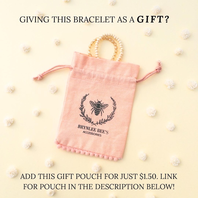May include: A pink velvet pouch with a drawstring closure and a bee logo. The pouch is decorated with a white pom-pom trim. The text "Brynlee Bee's Accessories" is printed on the pouch.  "ADD THIS GIFT POUCH FOR JUST &pound;1.50. LINK FOR POUCH IN THE DESCRIPTION BELOW!" is written below the pouch.