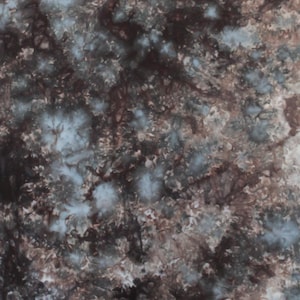 May include: Abstract tie-dye fabric with a blend of colors. The design features a mix of dark brown, light blue, and white hues, creating a textured, mottled appearance. The fabric's pattern is reminiscent of a cloudy sky or a watercolor painting.