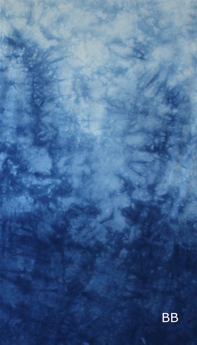 May include: A fabric textile featuring a tie-dye pattern in shades of deep navy blue and white. The design displays organic, cloud-like swirls and branching textures that transition from dark blue to light blue. The letters BB appear in white.