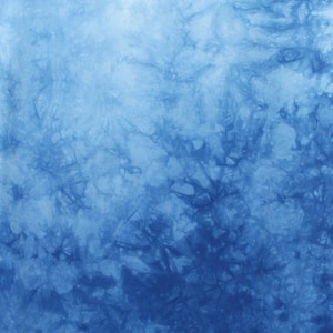 May include: Abstract tie-dye pattern in shades of blue, with a gradient effect from light to dark. The fabric has a textured appearance, with darker blue areas creating a visual depth. The letter "H" is at the bottom.