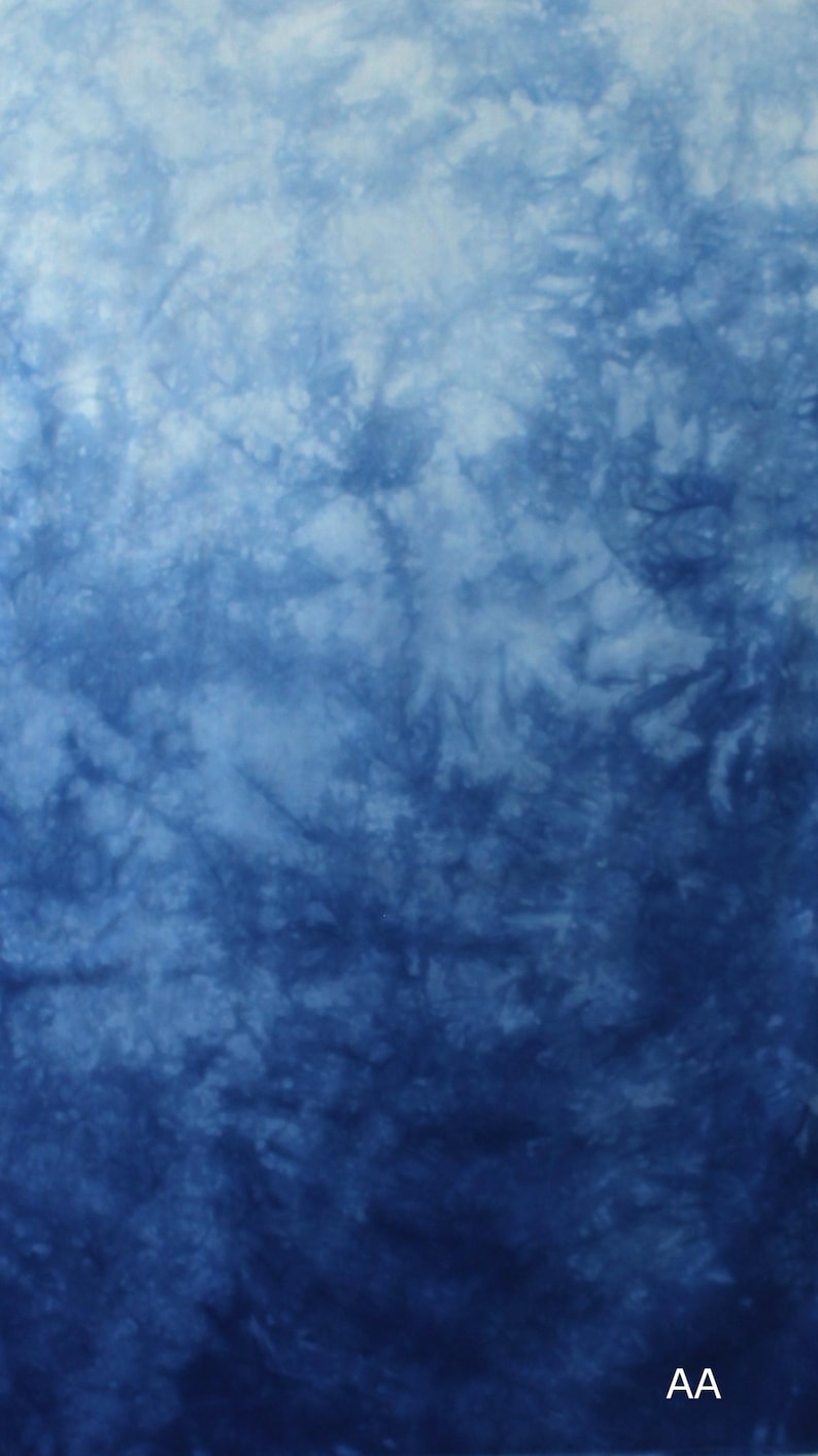 May include: A fabric featuring a tie-dye pattern in shades of blue and white, transitioning from a lighter blue at the top to a deeper, saturated indigo at the bottom. The letters AA are printed in white in the bottom right corner of the textile.