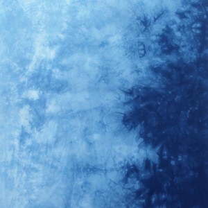 May include: Abstract textile with a tie-dye pattern in shades of blue. The fabric features a blend of light and dark blues, creating a textured, cloudy effect. The design is reminiscent of water or sky.