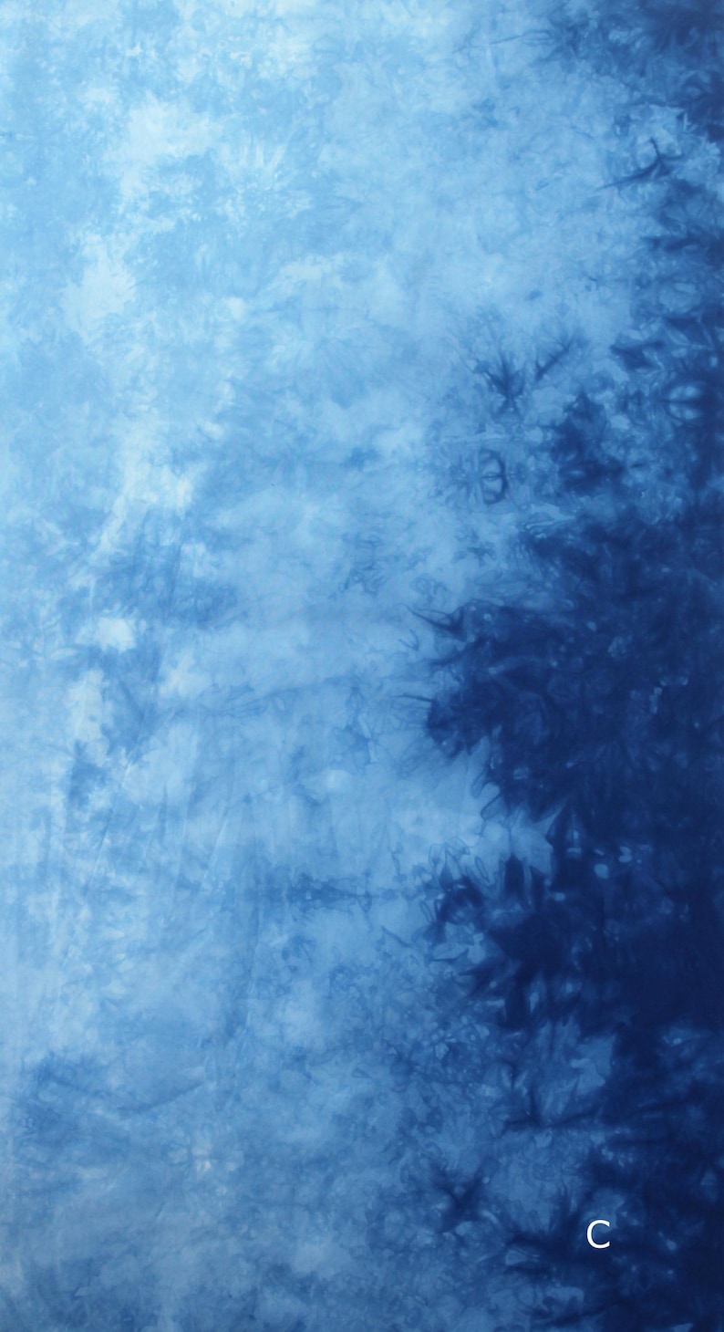 May include: Abstract textile with a tie-dye pattern in shades of blue. The fabric features a blend of light and dark blues, creating a textured, cloudy effect. The design is reminiscent of water or sky.