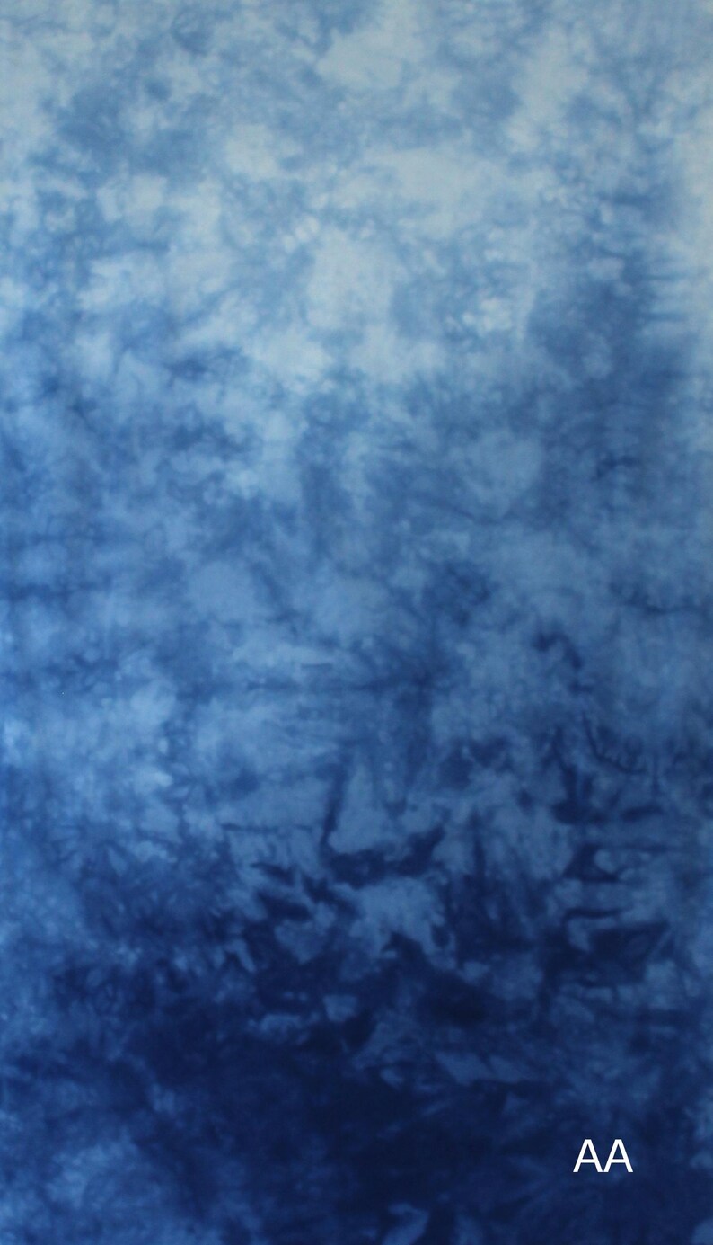 May include: A fabric textile featuring a tie-dye pattern with a gradient of blue shades, transitioning from a light sky blue at the top to a deep navy blue at the bottom. The letters AA are printed in white in the bottom right corner of the fabric.
