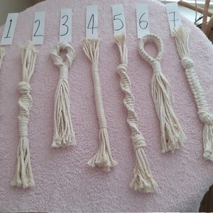 Puede incluir: Siete juguetes de cuerda de algodón blanco con diferentes nudos y diseños. Los juguetes están numerados del 1 al 7.