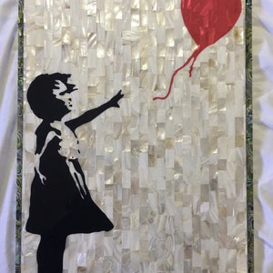 May include: A black and white silhouette of a girl reaching for a red heart-shaped balloon. The background is a white mosaic of mother of pearl.