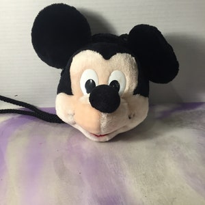 Puede incluir: Cabeza de Mickey Mouse de peluche negra y blanca con una cuerda negra atada. La cabeza es un peque&ntilde;o bolso de mano o una bolsa.