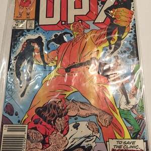 May include: A comic book cover featuring a red and orange superhero character with the text "DP7" and "New Universe" on the cover. The text "To save the clinic, Overshadow must die!" is also on the cover.