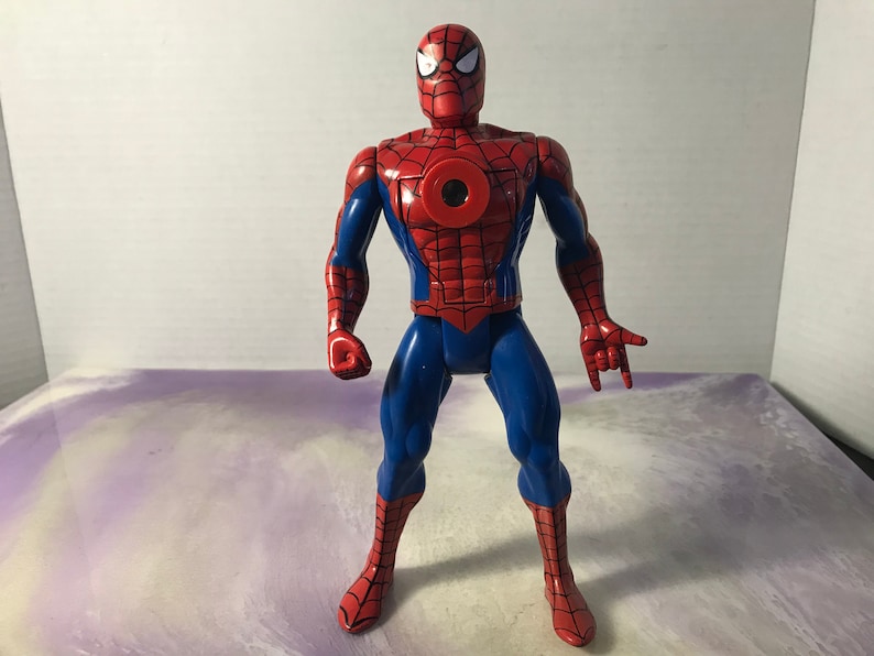 May include: A red and blue action figure of Spider-Man with a web design on his suit. The figure has a large red spider symbol on its chest.