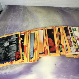 May include: A stack of trading cards featuring the boy band New Kids on the Block. The cards are yellow, red, and blue with images of the band members.