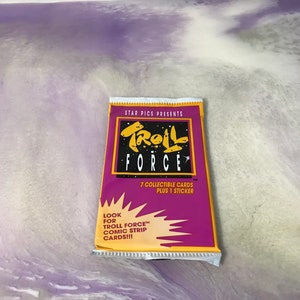 May include: A purple and yellow card pack with the text "STAR PICS PRESENTS TROLL FORCE" and "7 COLLECTIBLE CARDS PLUS 1 STICKER". The pack also has the text "LOOK FOR TROLL FORCE™ COMIC STRIP CARDS!!!".