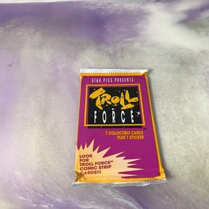 May include: A purple and yellow package of Troll Force trading cards. The package features a cartoon troll with a star and the text "Troll Force". The package includes 7 collectible cards and 1 sticker. Look for Troll Force comic strip cards!