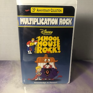 May include: A blue VHS tape with the title "Multiplication Rock" and a picture of characters from the Disney show "Schoolhouse Rock!" The tape is part of a 25th Anniversary Collection. The text "Knowledge Is Power!" is at the bottom of the tape.