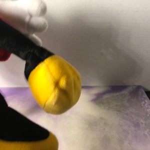 May include: A plush Mickey Mouse toy with red shorts, black shoes, and yellow gloves. The toy is made of soft, cuddly fabric and is perfect for cuddling.