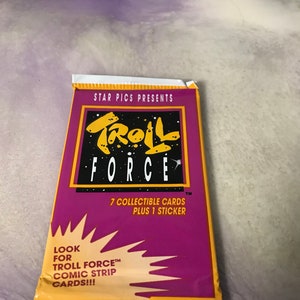May include: A purple and yellow package of Troll Force trading cards. The package features a cartoon troll with the text "Troll Force" and "7 collectible cards plus 1 sticker".