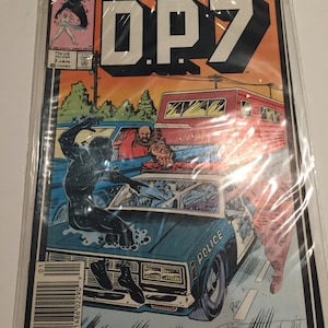 May include: A comic book cover featuring a black and blue superhero character, a police car, and the text "MARVEL new universe DP7".