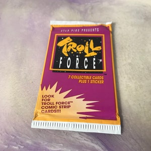 May include: A purple and yellow package for Troll Force collectible cards. The package features a cartoon troll with a star and the text "Troll Force" in a bold, white font. The package also includes the text "7 collectible cards plus 1 sticker" and "Look for Troll Force comic strip cards!!!".