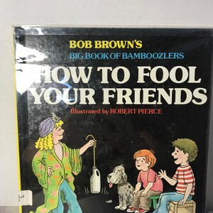May include: A book cover for "BOB BROWN'S BIG BOOK OF BAMBOOZLERS HOW TO FOOL YOUR FRIENDS" illustrated by ROBERT PIERCE. The cover shows cartoon illustrations of people and a dog, with text stating "46 MYSTIFYING TRICKS WITH SIMPLE MATERIALS."