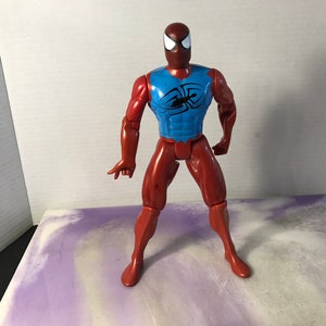 Puede incluir: Figura de acci&oacute;n roja y azul de Spider-Man con un s&iacute;mbolo de ara&ntilde;a negro en el pecho.