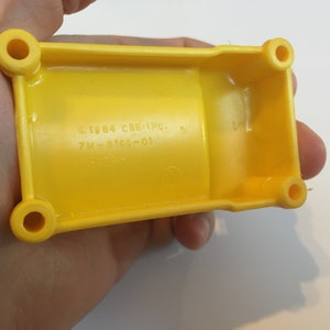 May include: Yellow plastic toy truck with a copyright date of 1984 and the text "CBS INC. 7M-6164-01".