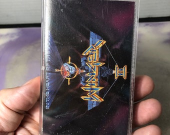 Könnte beinhalten: Ein Kassetten-Etui mit einem schwarzen und goldenen Design. Das Etui zeigt ein Band-Logo mit dem Text "Queensrÿche" und den Albumtitel "In the  Heart of the  Child".