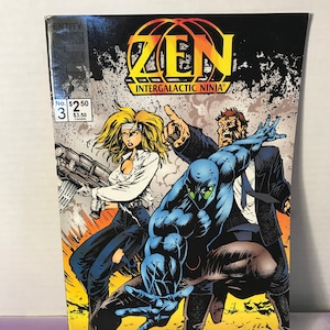 May include: Comic book cover for "ZEN Intergalactic Ninja" No. 3. The cover features a blonde woman with a gun, a blue-skinned ninja, and a man in a suit. The title is in yellow and black, with the text "PLUS TALES OF STARQUEST!"