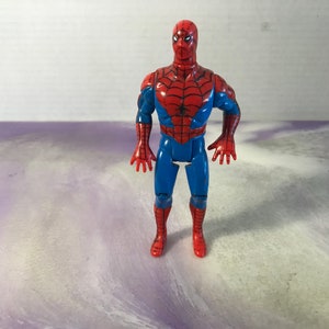 May include: A red and blue plastic action figure of Spider-Man. The figure has a web design on the chest and a black spider logo on the abdomen.