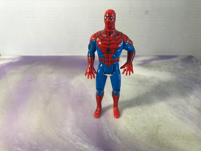 May include: A red and blue plastic action figure of Spider-Man. The figure has a web design on the chest and a black spider logo on the abdomen.