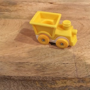 May include: A yellow toy train with white wheels and a yellow caboose. The train is made of plastic and has a simple design.